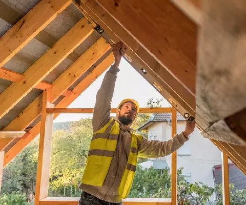 Un couvreur rénove une charpente